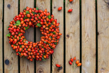 Ahşap arka planda gül kalça çelengi