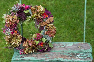 Eski ahşap sandalyede renkli sonbahar çelengi