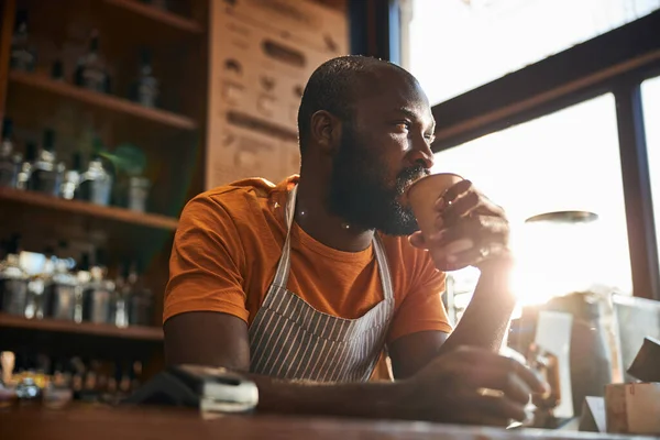 Guapo camarero masculino bebiendo café en el trabajo — Foto de Stock