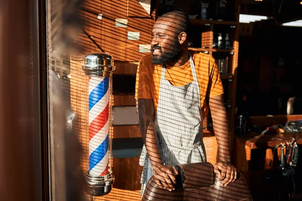 Baard Afro-Amerikaanse man staat bij het raam in de kapperszaak — Stockfoto