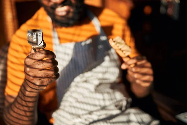 Afro American man holding vintage hair trimmer and brush — Stock Photo, Image