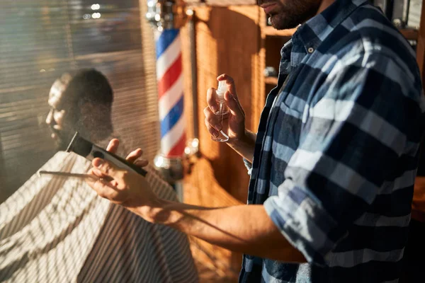 Barbeiro masculino desinfetando ferramentas de cabeleireiro antes do corte de cabelo — Fotografia de Stock