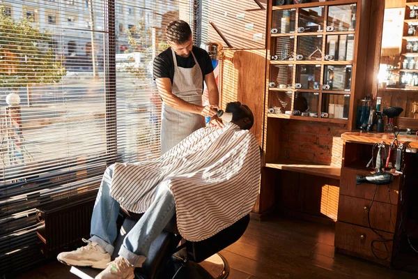 Barbeiro remover cabelos indesejados da barba do cliente após o corte — Fotografia de Stock