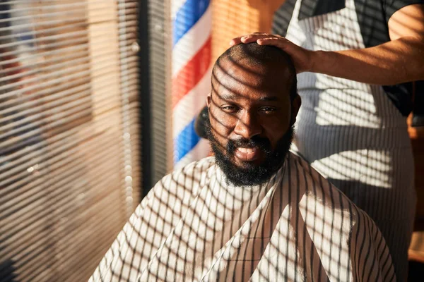 Glada afro amerikansk ung man besöker frisersalong — Stockfoto