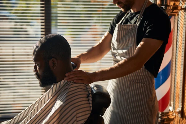 Bonito afro-americano recebendo corte de cabelo na barbearia — Fotografia de Stock