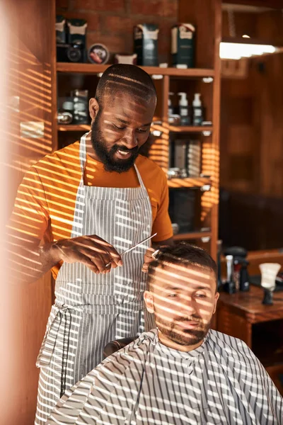 Snygg ung man som klipper sig i frisersalongen — Stockfoto