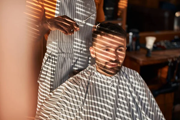 Бородатий молодий чоловік отримує зачіску в перукарні — стокове фото