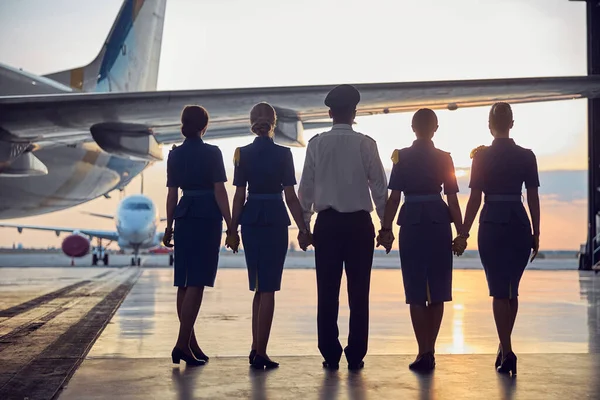 Vriendelijke mensen uit de luchtvaartindustrie die naar de lucht kijken — Stockfoto