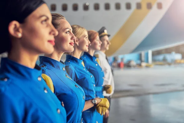 Charming female air hostess in blue uniform standing in the outdoors — Stock Photo, Image