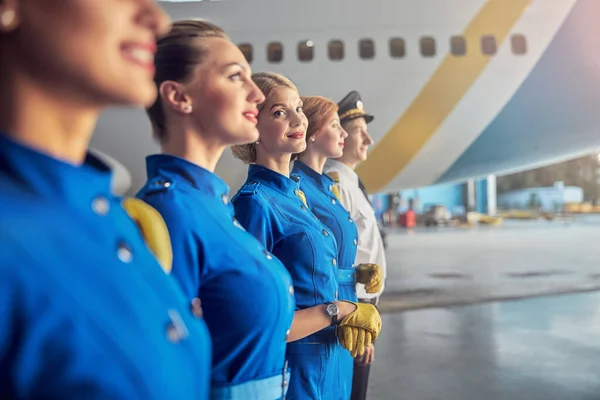 Azafatas bien parecidas y sonrientes en trajes de negocios esperando al pasajero — Foto de Stock