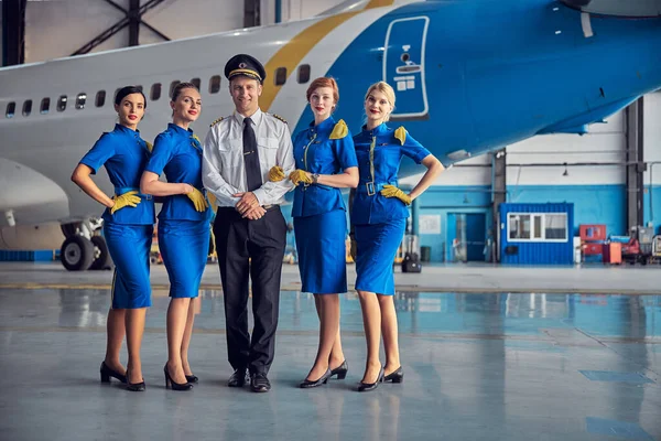 Cabin crew of a commercial airplane looking and smiling at the camera — Stock Photo, Image