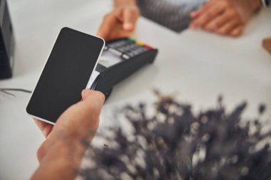 Müşteri satın almak için telefon yardımıyla ödeme yapıyor.