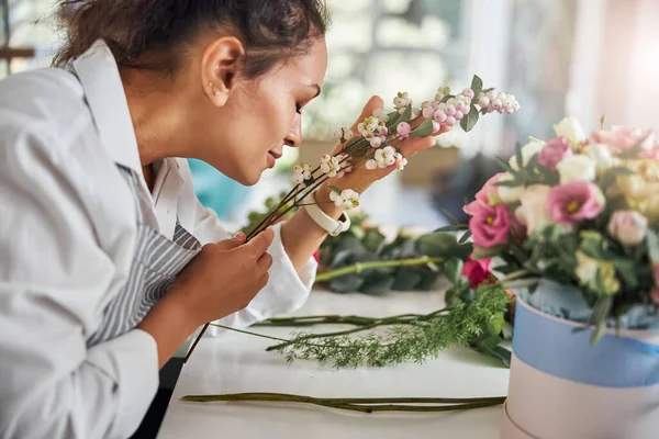 Trabajador profesional de la florería disfrutando del aroma de las bayas blancas — Foto de Stock