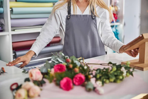 Elegant kvinna bär ett förkläde i en blomsterstudio — Stockfoto