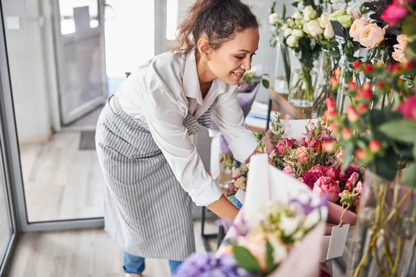 Charmante vrouwelijke bloemist sorteren van boeketten in een bloem studio — Stockfoto