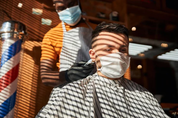 Красивий чоловік в медичній масці зачіска в перукарні — стокове фото