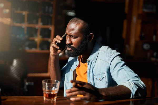 Hombre afroamericano guapo con cigarro hablando por celular —  Fotos de Stock