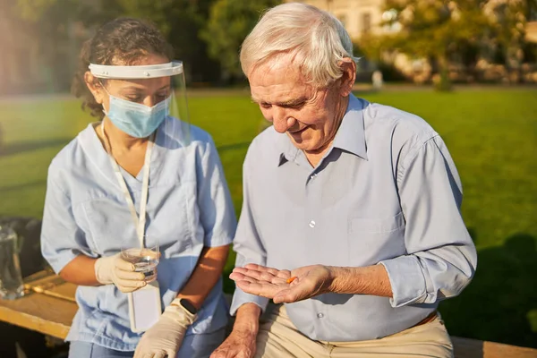 Oude patiënt die genezing krijgt van een vrouwelijke arts — Stockfoto