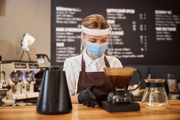 Munter kvinnelig barista tilbereder kaffe ved hjelp av chemex pour over kaffemaskin – stockfoto