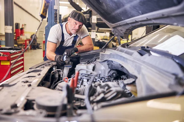 Mecánico de automóviles guapo trabajando en la estación de servicio de reparación de automóviles — Foto de Stock