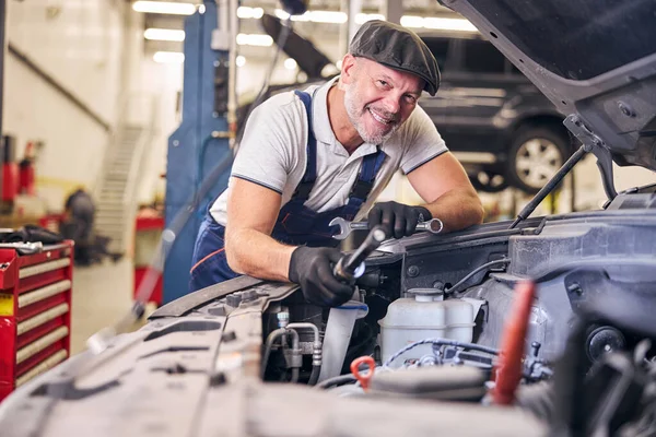 Fröhlicher Automechaniker bei der Arbeit in der Kfz-Werkstatt — Stockfoto