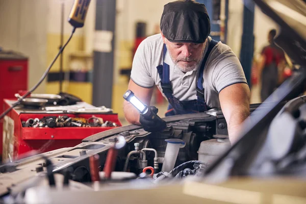Bärtiger Automechaniker repariert Auto an Tankstelle — Stockfoto