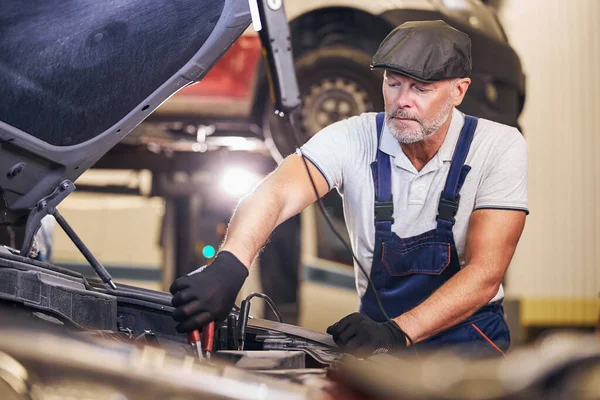 Bärtiger männlicher Arbeiter repariert Auto-Motor an Tankstelle — Stockfoto