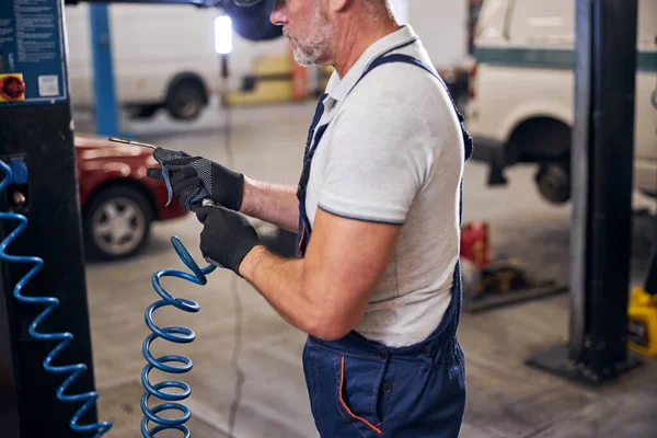 Automechaniker mit Luftblaspistole an Tankstelle — Stockfoto