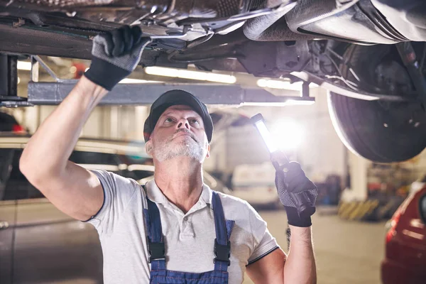 Vousatý muž pracovník oprava auto v autoopravně — Stock fotografie