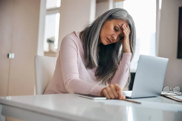 Vacker kvinna i rosa tröja mår dåligt på jobbet — Stockfoto