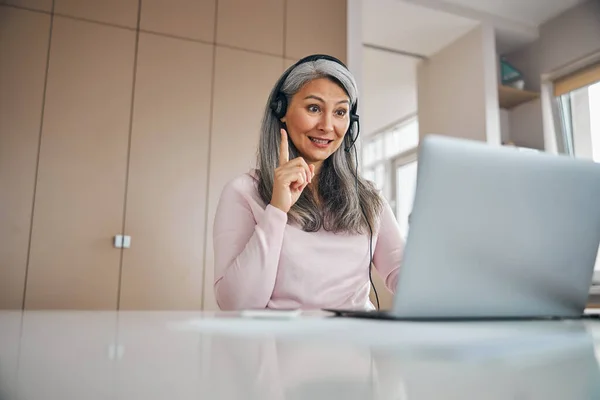 Vuxen kvinnlig lärare som arbetar med studenter på nätet på videosamtal — Stockfoto