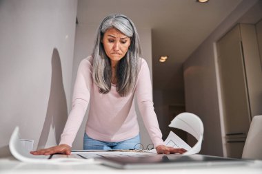 Evde proje üzerinde çalışan kafası karışık bir kadın.