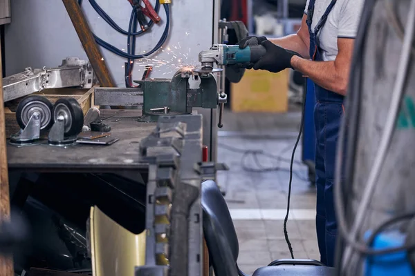 Mécanicien meulage de pièces métalliques de voiture dans le garage — Photo