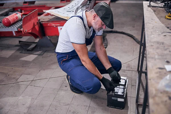 Mécanicien barbu travaillant dans un atelier de réparation automobile — Photo