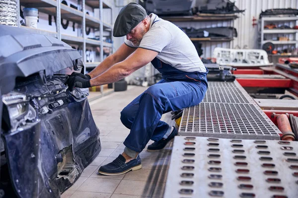 Profesional mecánico de automóviles que trabaja en el taller de reparación de vehículos — Foto de Stock