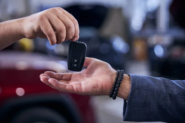 Mechaniker reicht Mann modernen elektronischen Autoschlüssel — Stockfoto