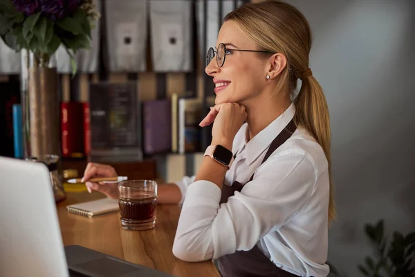 Elegante donna caucasica che si tiene per mano sotto il mento nella caffetteria — Foto Stock