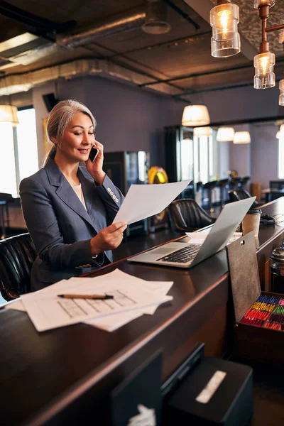 Empresária alegre tendo conversa telefônica no trabalho — Fotografia de Stock