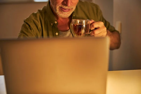 老先生一边喝茶一边看电脑屏幕 — 图库照片