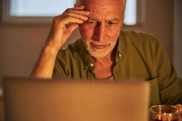 Elderly citizen feeling tired from working on his laptop — Stock Photo, Image