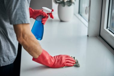 Pencere pervazının temizlenmesi ve dezenfekte edilmesinden sorumlu adam