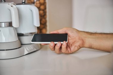 Akıllı su ısıtıcısının sahibi akıllı telefonla çalıştırıyor.