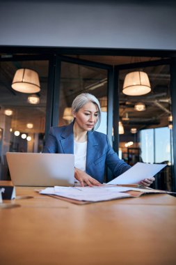 Ofiste belgelerle çalışan güzel bir iş kadını.