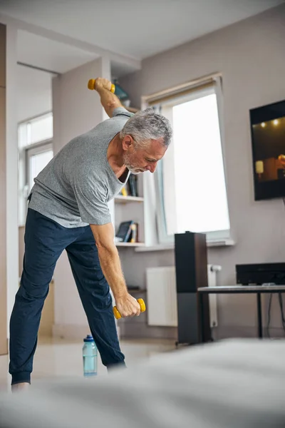 Enerjik yaşlı adam evde fiziksel egzersiz yapıyor. — Stok fotoğraf