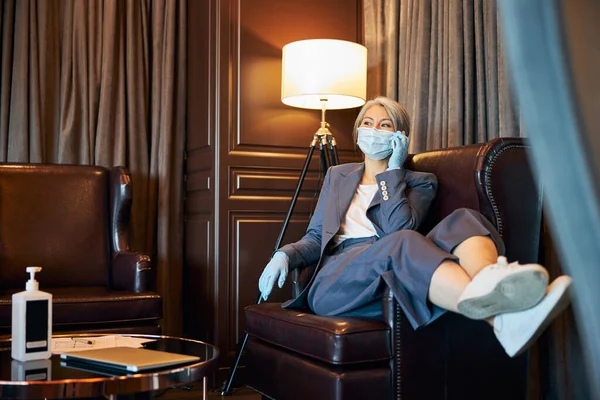 Elegante Geschäftsfrau in medizinischer Maske telefoniert — Stockfoto