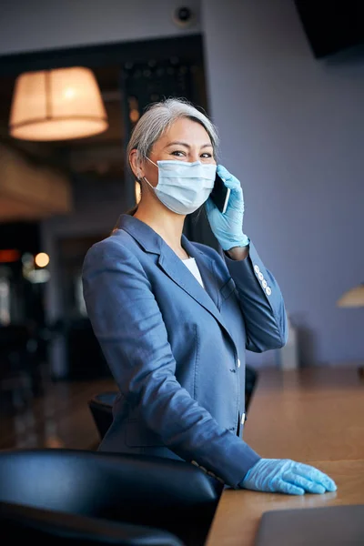 Charmante vrouw in medisch masker praten op mobiele telefoon — Stockfoto