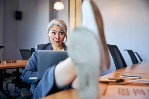 Mulher de negócios espantada trabalhando no laptop no escritório — Fotografia de Stock