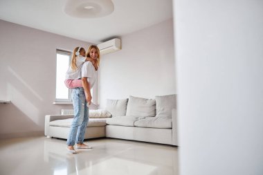 Genç ve güzel anne hafta sonu evde güzel kızıyla eğleniyor.