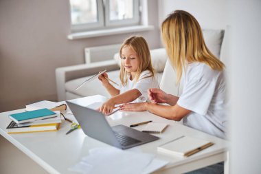 Çalışma akışının görüntüsü çekici bir kadın ve küçük bayan içerideki beyaz masada.