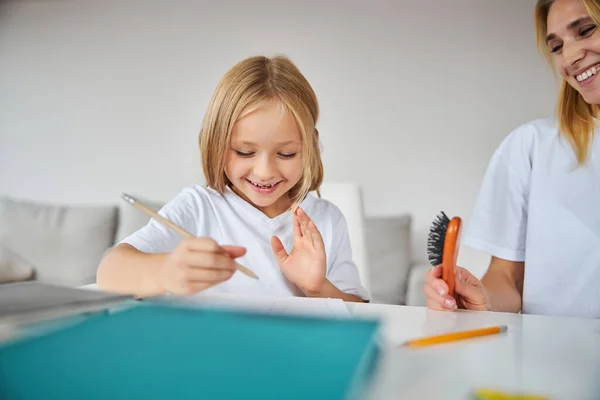 Mooi klein missen in casual kleding tijd doorbrengen met nanny in huis — Stockfoto